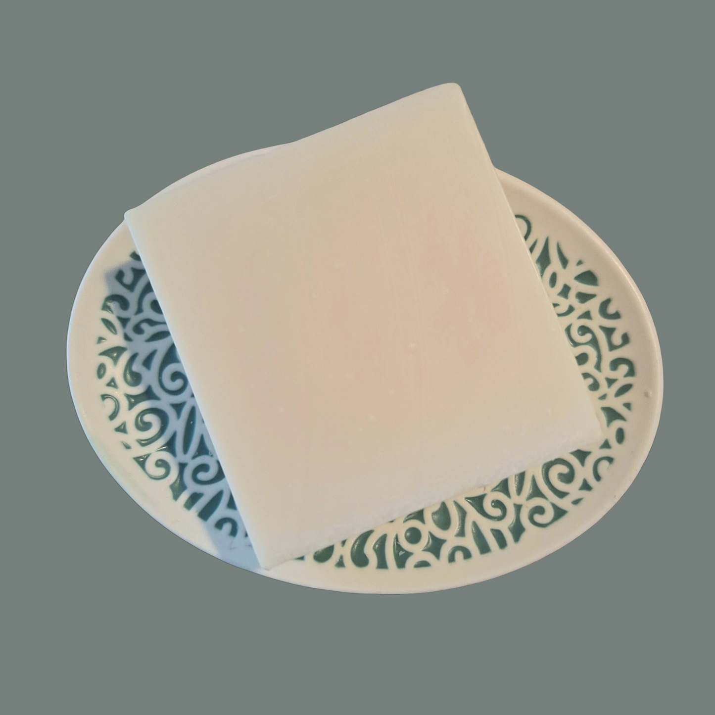 white olive oil soap on soap dish with olive green background